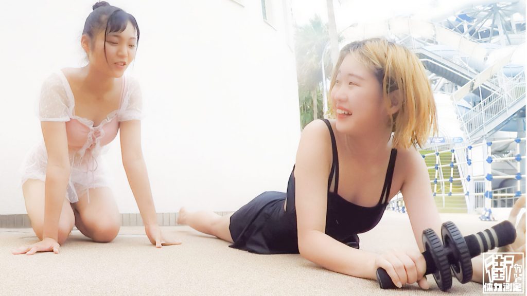 ピンク水着のJKと黒水着の専門学生の姉妹が膝つき腹筋ローラーチャレンジしている画像